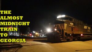 Night train crossing with text “The Almost Midnight Train to Georgia” in yellow.