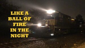 Night train with bright headlights and overlayed text “Like a ball of fire in the night”