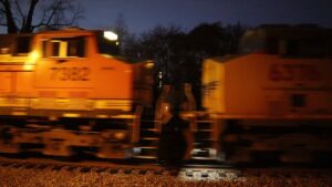 Two locomotives passing at night with motion blur on tracks