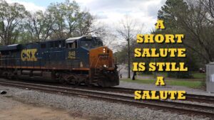 CSX locomotive 848 on tracks with large yellow text “A short salute is still a salute” on the right.